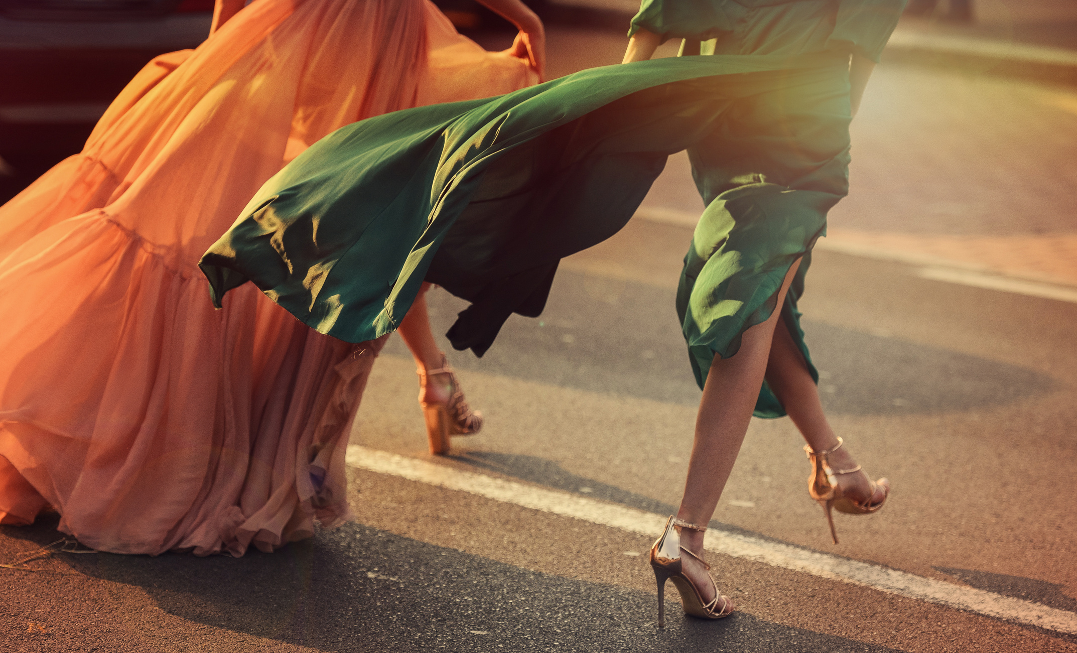 Women wearing elegant dresses, street style detail.